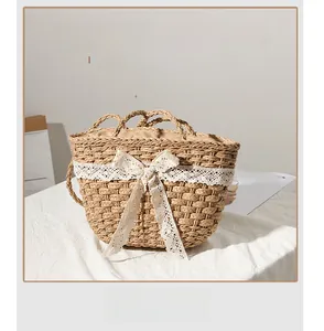 Detailed close-up of natural straw bag featuring large white lace bow and woven texture