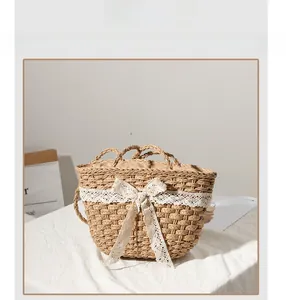 Detail of straw woven tote bag featuring a white lace bow and natural fiber texture