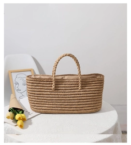 Detail of hand-woven straw tote bag on a lace tablecloth with a bouquet of yellow tulips