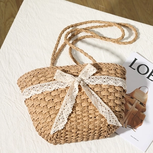 Handwoven straw bag with elegant cream lace bow detail for beach and summer vacations
