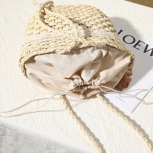 Handwoven straw beach bag with delicate white lace trim and drawstring liner for summer