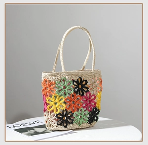 Detail der beigefarbenen Häkeltasche mit leuchtenden, bunten Strickblumenmustern