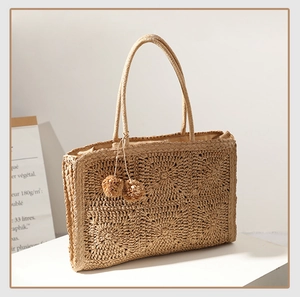 Vista dettagliata della borsa tote in paglia intrecciata con nappe e texture rafia