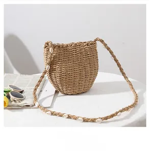 Dettaglio della borsa in paglia intrecciata con decorazioni in conchiglie estive