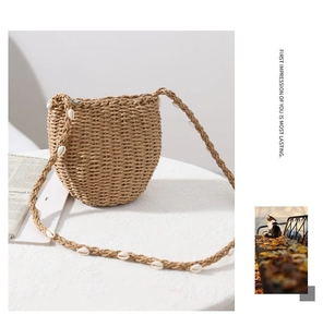 Dettaglio della borsa a tracolla in paglia intrecciata con conchiglie bianche da mare