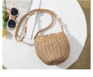 Dettaglio della borsa a tracolla in paglia intrecciata con decorazioni di conchiglie