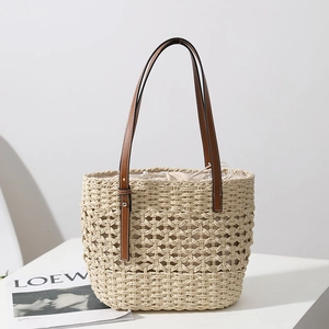 Handmade hollow straw tote bag with brown leather handles and drawstring lining
