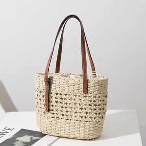 Hollow straw woven tote bag with brown leather handles for summer beach holidays