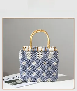 Detail of diamond pattern cotton weave bag with natural bamboo handles on a table