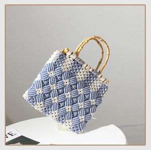 Detailed side view of handcrafted blue and white lattice macrame bag with bamboo handles