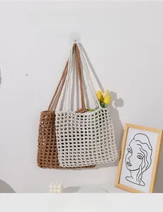 Close-up of hollow woven cotton tote bags in brown and beige with long shoulder straps