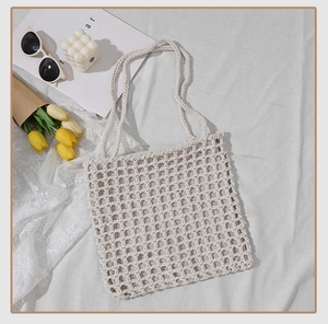 Detail of hand-woven off-white cotton mesh tote bag with minimalist square hollow texture