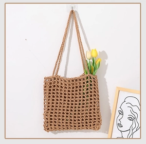 Detail of hand-woven hollow mesh tote bag in earth tones with stylish tulip decoration