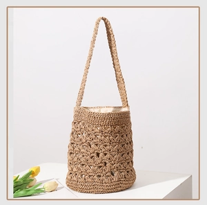 Detail of hand-woven straw bucket bag texture with tassels and interior cloth lining