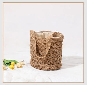 Close-up of hollowed-out crochet pattern and soft linen lining on straw bucket bag