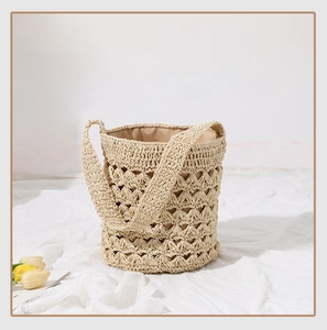 Detailed view of handmade woven straw bucket bag with hollow crochet texture and lining