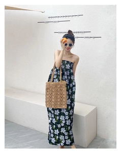 Détail d'un sac cabas en tricot ajouré tissé à la main avec une robe d'été fleurie