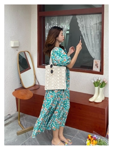Détail d'un sac à bandoulière en crochet fait main blanc avec une robe fleurie verte