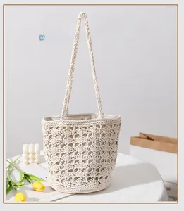 Detailed close-up of hollow-out crochet pattern and beige cotton thread on a beach tote