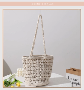 Detail of cream handmade crochet bucket bag with hollow floral pattern on a table
