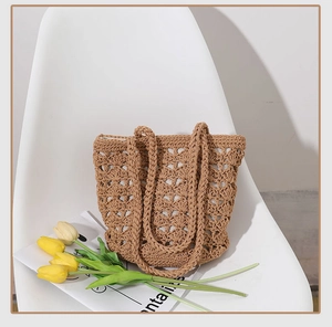 Close-up of hollow crochet texture on handmade khaki woven straw tote bag for summer beach