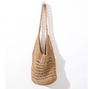 Detailed close-up of hollow mesh handwoven texture on a khaki straw tote bag