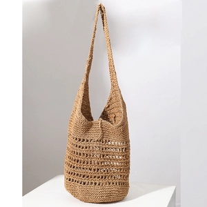 Detailed close-up of hollow-out woven pattern on a large capacity straw shoulder bag