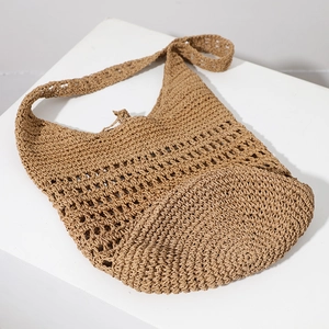 Large woven straw beach bag with hollow crochet design and wide shoulder strap for summer
