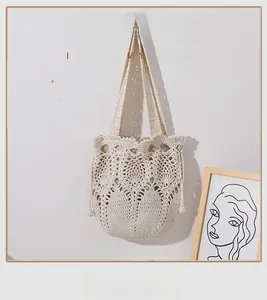 Detailed view of beige handmade crochet bag with hollow patterns and drawstring closure