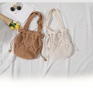 Detail of hand-woven crochet bucket bags with drawstring closure and floral hollow patterns