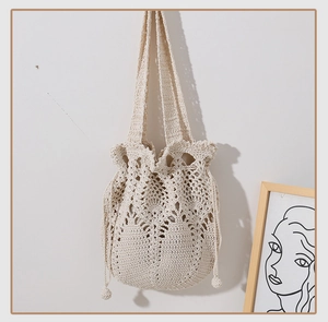 Detailed close-up of cream handmade crochet shoulder bag with intricate lace weave and drawstring