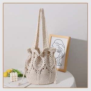 Detail of crochet bucket bag featuring intricate floral patterns and drawstring closure