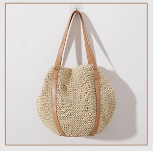 Close-up of woven straw tote bag featuring brown faux leather straps and fine texture