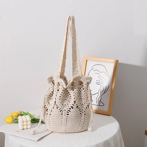 Handcrafted cream crochet bucket bag with intricate floral patterns and drawstring closure