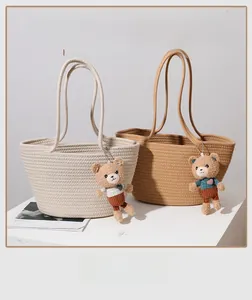 Close-up of woven cotton thread shoulder bag with a cute plush bear charm accessory