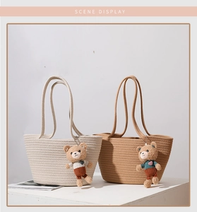 Detail of woven cotton tote bags in beige and brown with cute teddy bear pendants