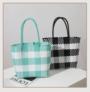 Detail of woven plaid tote bags in mint green and black check patterns with sturdy handles
