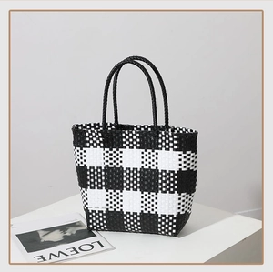 Detail view of black and white checkered woven tote bag with sturdy double handles