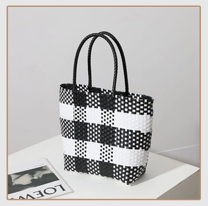 Detail of black and white checkered woven tote bag texture and round handles