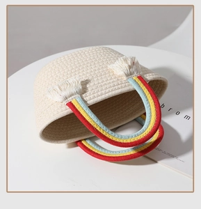 Detail of hand-woven cotton bag featuring rainbow handles and decorative white tassels