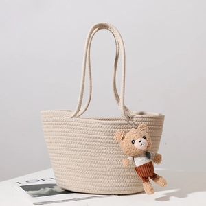 Beige cotton rope woven tote bag with a cute plush bear pendant for beach vacation