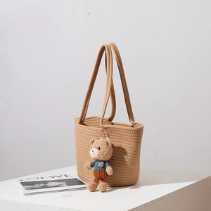 Handwoven straw shoulder bag with cute teddy bear charm for beach vacation and casual use