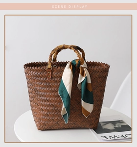 Detail of dark brown woven tote bag featuring bamboo handle and decorative silk scarf