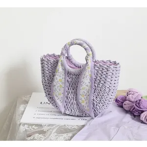Detailed close-up of light purple woven bag featuring floral silk scarf and wavy edge design