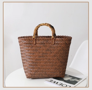 Detail of dark brown woven tote bag featuring natural bamboo handles and metal rivet fasteners