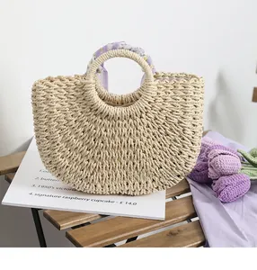 Close-up of woven straw handbag featuring purple floral scarf handle and fabric lining