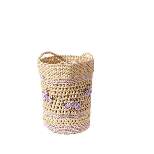 Handwoven raffia straw bag with purple floral embroidery and drawstring closure