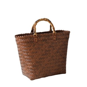 Handmade brown straw woven tote bag with vintage bamboo handles and metal rivet details