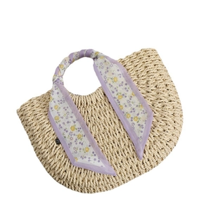 Chic cream straw handbag with purple floral silk scarf on handle for beach vacations