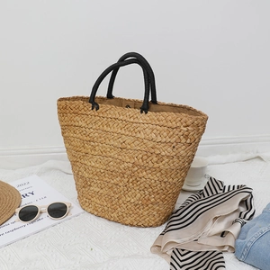 Large woven straw tote bag with black rope handles for summer beach vacations